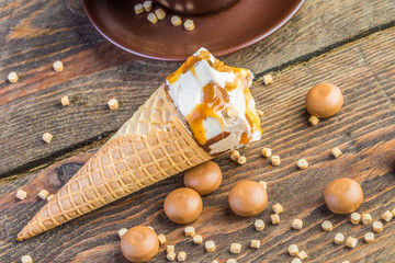 Ice cream cone on wooden table with cup

