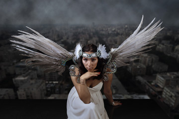  woman with angel wings on the background of the smoggy city