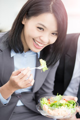 businesswoman eat salad in office