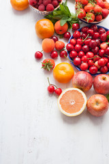 Summer fruits and berries on a white table, with space for text, selective focus