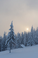 Winter landscape with wooden house in the mountains