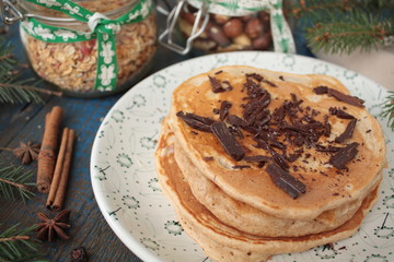 Christmas pancakes from whole wheat flour with chocolate and butter, nuts, muesli, milk. nutritious, healthy, festive Breakfast