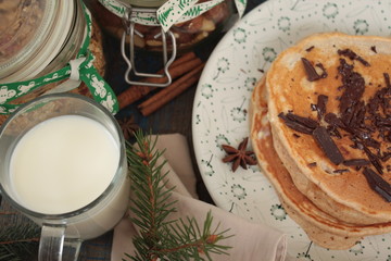 Christmas pancakes from whole wheat flour with chocolate and butter, nuts, muesli, milk. nutritious, healthy, festive Breakfast