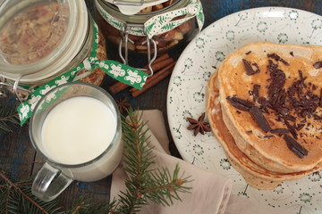Christmas pancakes from whole wheat flour with chocolate and butter, nuts, muesli, milk. nutritious, healthy, festive Breakfast