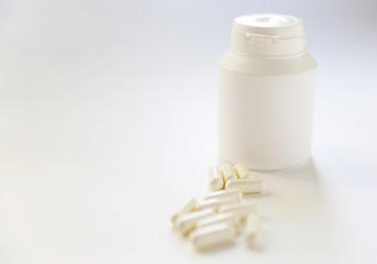 White big Pills in the jar, capsules are on the white background