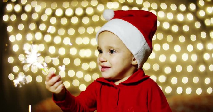 baby plays with a flare sparkling smiles of joy for the New Year celebrations, they are happy of the holiday season. waiting for Santa Claus love for the Christmas holiday and the family together.