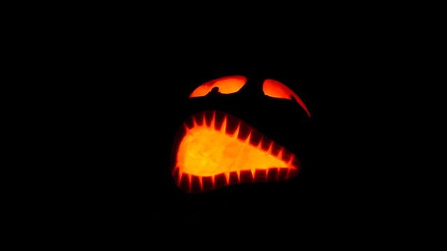 Shining scary halloween pumpkin face at night.