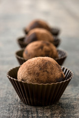 Homemade chocolate truffles on wooden table

