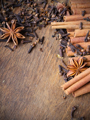 cinnamon sticks, star anise and cloves on wooden background