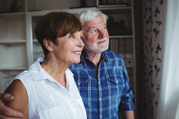 Senior couple looking through window