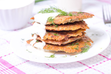 Healthy breakfast. Delicious homemade potato pancakes on plate with sour cream. Selective focus, closeup.