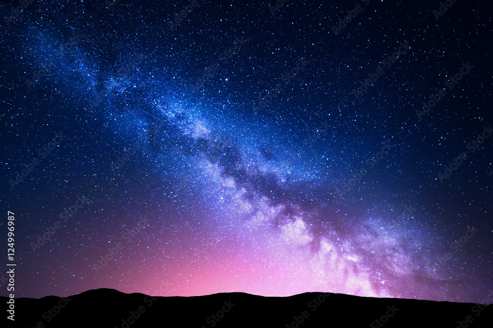 Wall mural milky way and pink light at mountains. night colorful landscape. starry sky with hills at summer. be