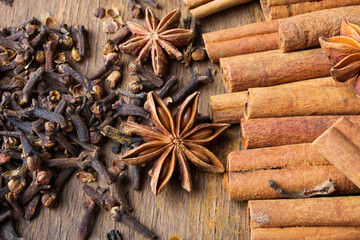 cinnamon sticks, star anise and cloves on wooden background