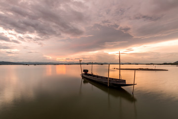 Fototapeta na wymiar Beautiful silhouette fishing boat in lake at Twilight sky. landscape