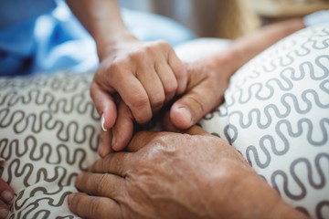 Nurse holding hands of senior woman