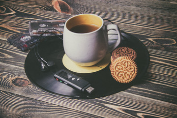tea in cup with sweet cake on vinyl records