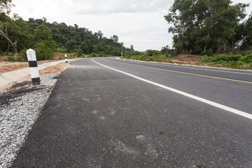 asphalt road and mountain forest area.