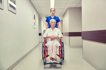 nurse with senior woman in wheelchair at hospital