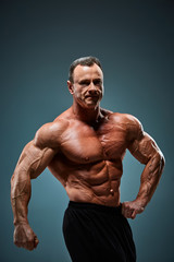 Fototapeta premium torso of attractive male body builder on gray background.