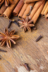 cinnamon sticks, star anise and cloves on wooden background