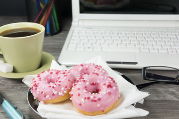 Kaffee und Donuts auf einem Bürotisch