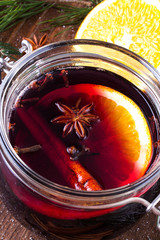 Christmas drink with orange fruit, anise, cinnamon and cloves on wooden table