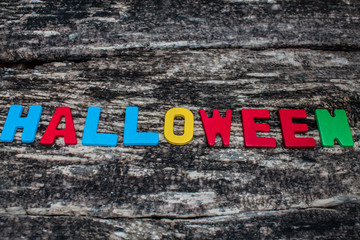 colorful word halloween on wooden background