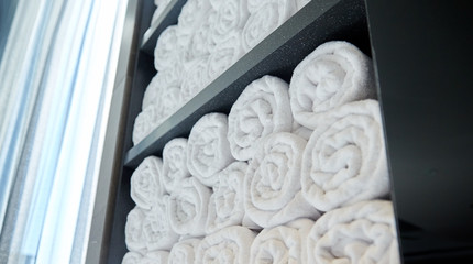 rolled white bath towels at hotel spa