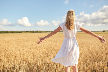 happy young woman in white dress on cereal field