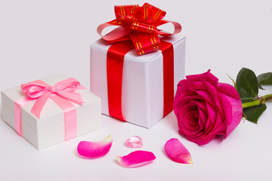Gift boxes with bows, red ribbons, rose and petals.