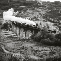 Eine Dampflockomotive fährt über das Glenfiann Viaduct
