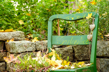 Gartenglück ein bemalter Gartenstuhl im Herbst
