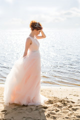 Fototapeta na wymiar Portrait of beautiful bride standing by the beach at sunset
