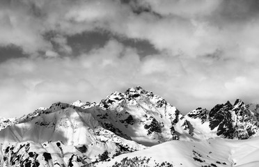 Black and white snow slope and winter sunlight mountains in clou