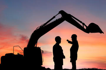 Silhouette engineer standing orders for construction crews to work safely on high ground over...