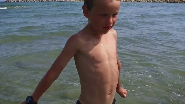 Little boy comming out from water, close up, slow motion