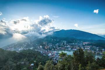 Aerial view of clusters of buildings nestled in the green valley of Sapa, Vietnam