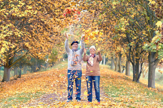 bunte Blätter werfen, Senioren genießen einen Tag im Herbst