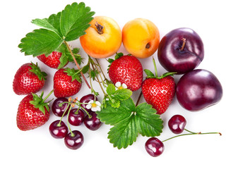 Fresh fruits and berries in still life with green leaves