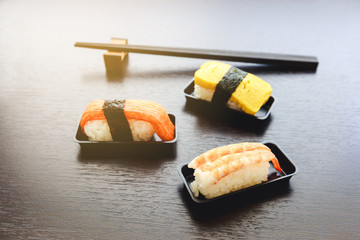 Sashimi fish, shrimp and egg set on the black plate