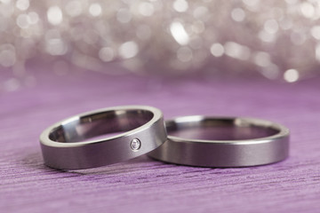 Silver wedding or engagement rings, sparkling bokeh background