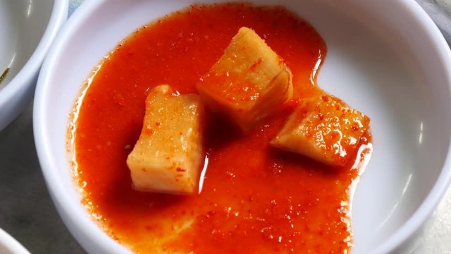 Pick up KKAKDUGI with chipsticks. Sliced radish kimchi
