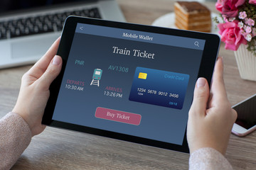 woman hands holding tablet PC computer with train ticket