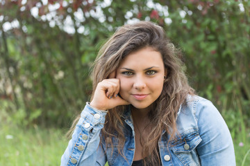 Fototapeta premium Portrait of cool long haired beautiful teenage girl staring at the camera outdoors. 