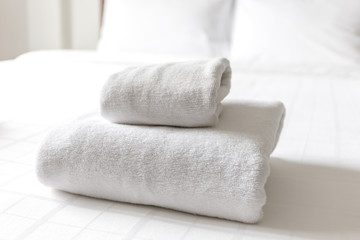 Stack of white cleaning folded tower on the white bed