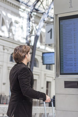 Passenger looking at timetable board