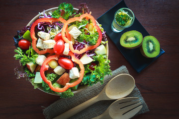 Kiwi sauce and mix salad with fruit and vegetable on wooden bowl