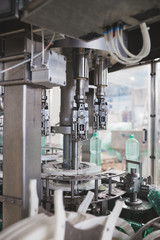 Industrial factory indoors and machinery. Robotic factory line for processing and bottling of pure spring water into canisters and bottles. Selective focus. Short depth of field.