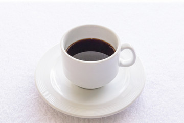 Black coffee cup on  white towel