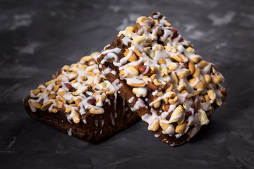 piece of cake, cookies with nuts and white icing on concrete bac